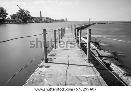 Exterior daytime black and white long exposure stock photo of concrete trail on Bird Island Pier in Niagara River adjacent to Lake Erie in Buffalo, New York