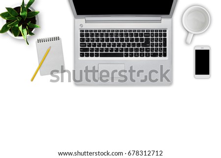 Top view of modern laptop computer, notebook with pencil, empty cup, cell phone and flowerpot isolated over white background. Workplace of business person. Up-to-date gadgets. Technology concept