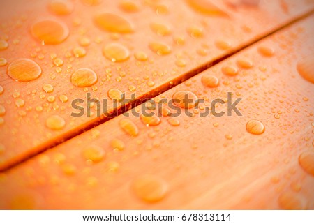 Water drops on wooden background close up