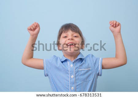 Cute little years girl raises her hands in a victory sign isolated
