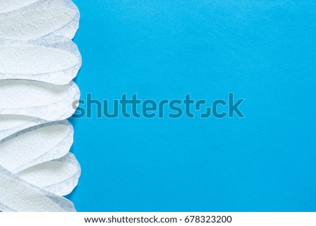 Lady's white sanitary pads on blue background with copy space