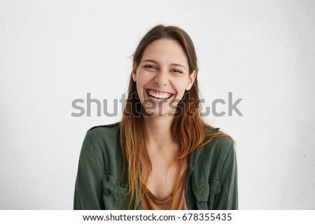 Good-looking female with sincere smile rejoicing her success at work having good mood showing her positive emotions. Woman with gentle smile. People, happiness, facial expressions and emotions Royalty-Free Stock Photo #678355435