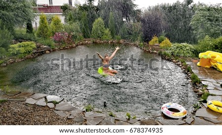 Girl in the water swims in the rain