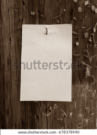  Plain paper ready for text nailed to telephone pole surrounded by nails, tacks, and staples in sepia tone / Old style message board in sepia         