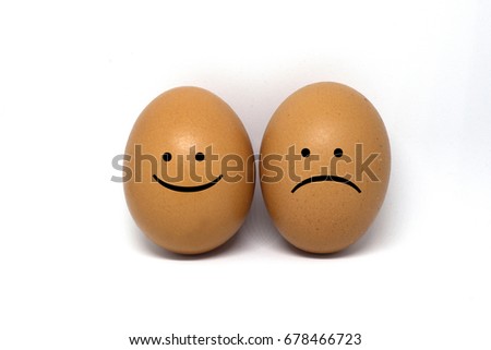 Two brown eggs with sad and happy face on white background.