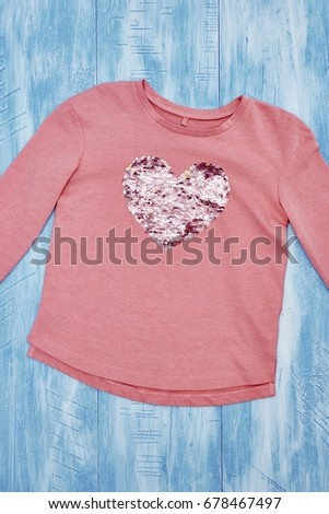 A studio photo of a girls love heart t-shirt