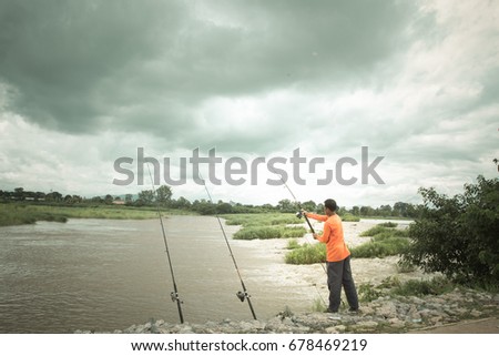 people with a fishing  on the river bank. The concept of a Sunday holiday rural getaway .