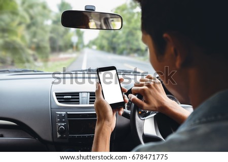 man looking at phone inside car