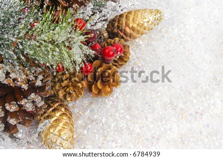 Pine branch with berries, ornaments, cones and snow