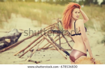 Young redhead girl enjoys hot summer day at the beach.