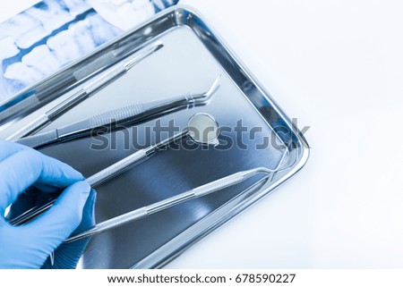 Selective focus hand of dentist holding a dental tool.