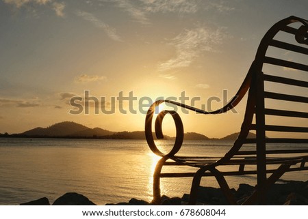 Sea view with yellow chair and colorful sunrise