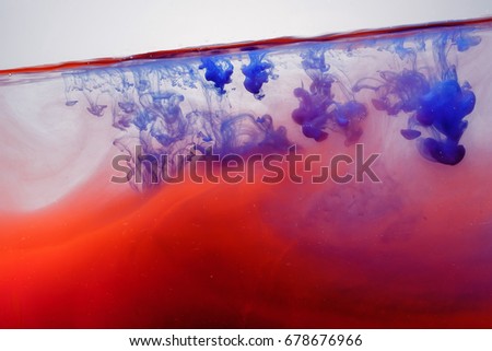 A paint splash in the water. Abstract background. Red and blue paint