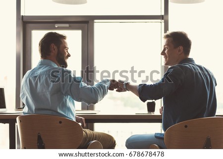 Happy youthful guys cooperating together at work in office Royalty-Free Stock Photo #678678478