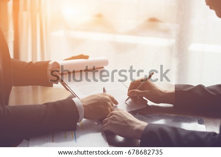 Businessperson Signing Contract about insurance, Two men writing with pen sign of modest agreements form In modern office, morning light, vintage color, success of business partners concept Royalty-Free Stock Photo #678682735