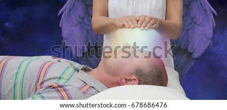 Angelic help during a healing session - female hands hoovering above a male patient's face channeling energy together with a higher power in the background depicting Angelic help
 Royalty-Free Stock Photo #678686476