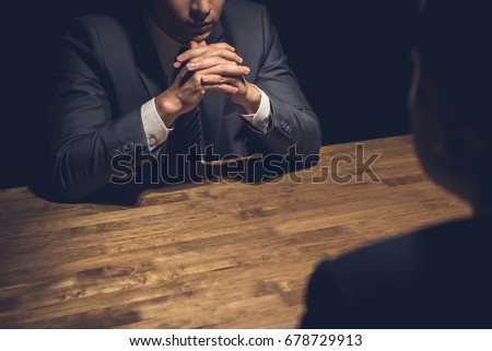 Detective interviewing suspect in dark room - investigation and interrogation concepts Royalty-Free Stock Photo #678729913