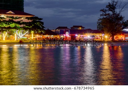 Colorful light of restaurants on the beach in Sihanoukville. Cambodia at night with reflection in the water