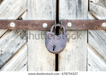 Old wooden door with the padlock. Close up
