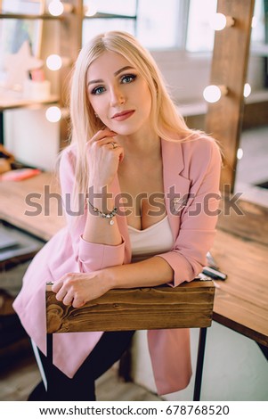 Make-up artist beautiful blonde woman posing near mirror in make-up room. Retouched portrait