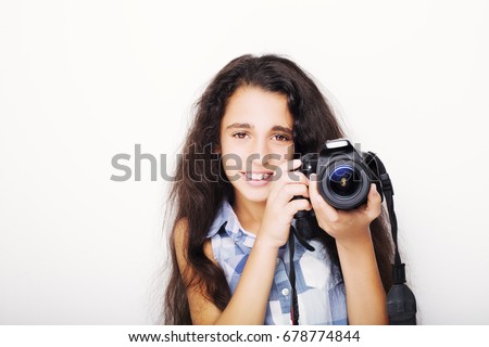 Cute brunette little girl holding an photo camera, isolated on white background