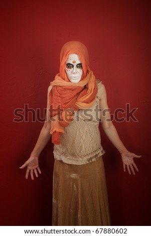 A lady with dramatic All Souls Day makeup and a orange scarf