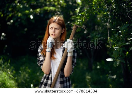 Woman with a hoe in the garden                               
