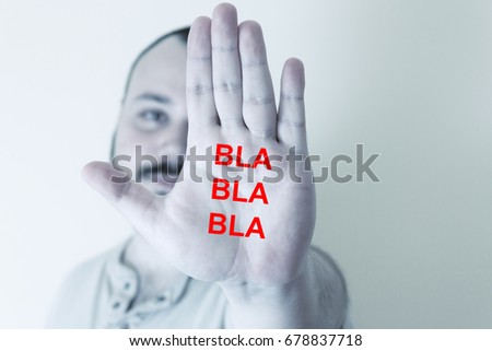The inscription "bla bla bla" is on the man's palm. Indifference.