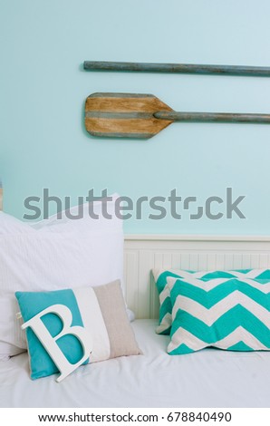 A rustic beach surf themed interior decorated room, with boat paddles and the letter B, in  a relaxing bohemian fresh setting.
