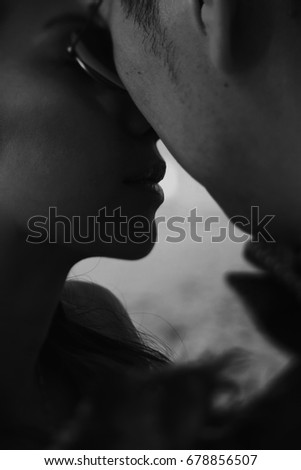 Black and white picture of faces touching in the kiss