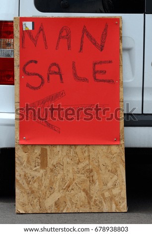 Humor arrow directional sign for Man Sale on red cardboard on placard