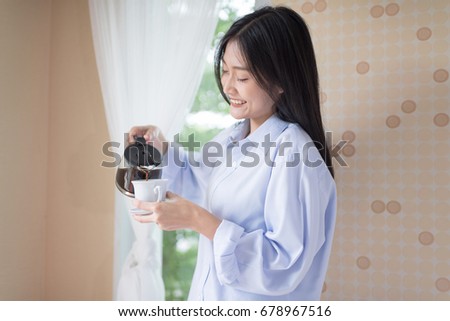 Morning coffee is my daily routine.Woman pouring hot cup of coffee in morning sunlight
