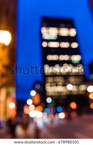 Bokeh lights background of modern skyscraper building at night in evening illuminated in Montreal, Canada