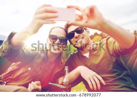 travel, hiking, technology, tourism and people concept - smiling couple of travelers taking selfie by smartphone at camping
