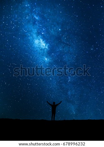 Man who feels on top of the world looking at the milky way / soft focus picture /  Blue tone concept