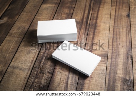 Photo of blank business cards on wood table background. Template for ID. Top view.
