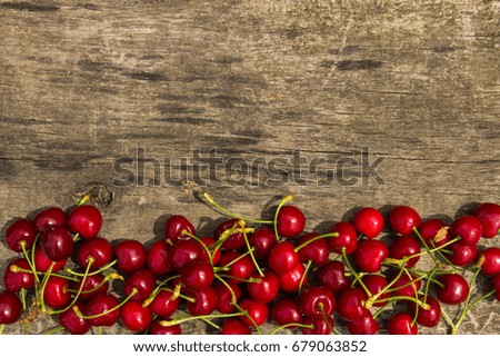 Red cherry fruits on wooden background. Top view with copy space