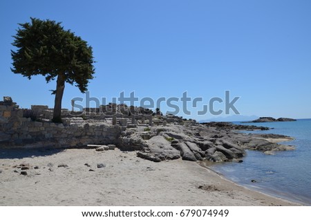 Agios Stefanos, Kefalos, KOS, Greece, Archaeological site bordering the sandy beach overlooking a small church, swim crossing possible towards the small island to explore