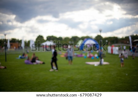 People / Family in a recreation park. Abstract blur people picnic in public park with family or friends, urban leisure lifestyle. Defocused  background. Relaxation and recreation concept.