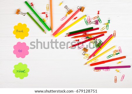 Colorful pencils and felt-tip pens and other chancery on white wooden background with empty space for text. Back to school concept.