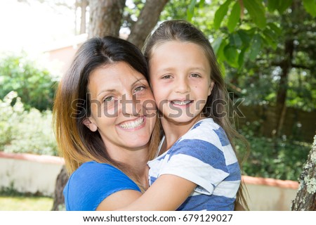 Mother and child are hugging and having fun outdoor in nature
