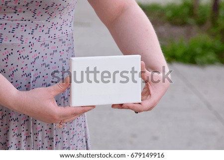 Woman Holding a Tiny Canvas