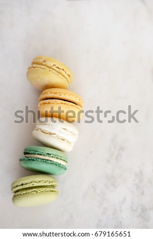 Colorful assorted french macarons on a white marble background.  