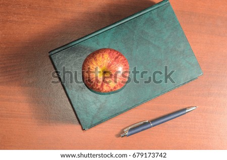 Book pen and apple