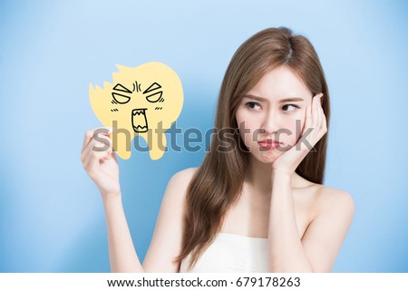 woman take decay tooth billboard and feel angry on the blue background