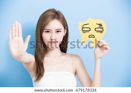 woman take decay tooth billboard and show stop gesture on the blue background