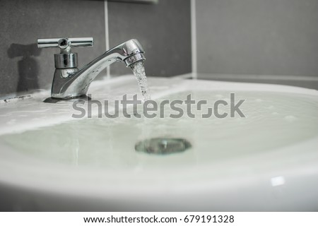 Overflowing water from the washbasin Royalty-Free Stock Photo #679191328