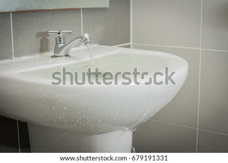 Overflowing water from the washbasin Royalty-Free Stock Photo #679191331