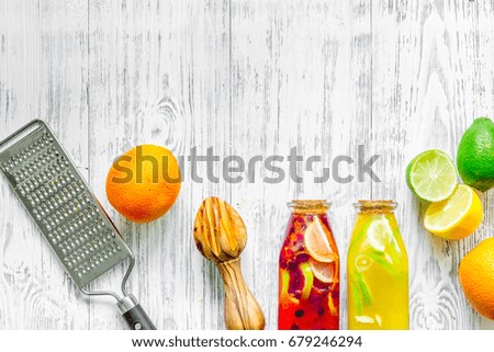 Bottle of fresh lemonade and fruits on grey table background top view copyspace