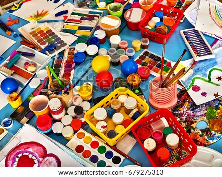 Kindergarten tables with painting brush. Preschool class waiting kids. Playroom with objects on table. Top view for art room. Materials for creative handwork. All for children's creativity still-life.